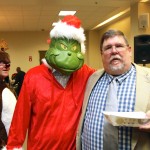 The Grinch checks NEMPA President Keith Griffin's plate while Rudolf flies cover.
